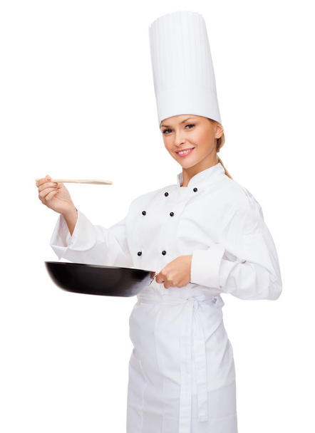 Smiling female chef with pan and spoon - Zdjęcie, obraz