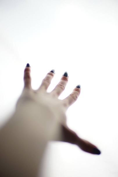 Γυναικείο χέρι σε λευκό φόντο με απλωμένα δάχτυλα. - Φωτογραφία, εικόνα