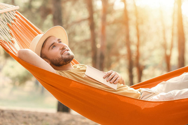 Hombre joven relajándose en la hamaca al aire libre - Foto, Imagen