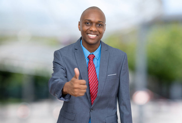 African american businessman showing thumb up outdoors in the city - Fotó, kép