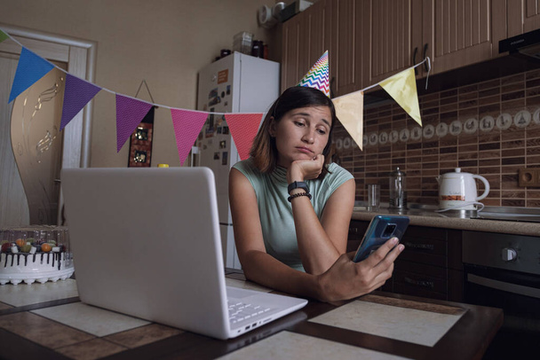 Girl celebrating birthday online in quarantine time. Woman celebrating her birthday through video call virtual party with friends. Authentic decorated home workplace. Coronavirus outbreak 2020. - Foto, imagen