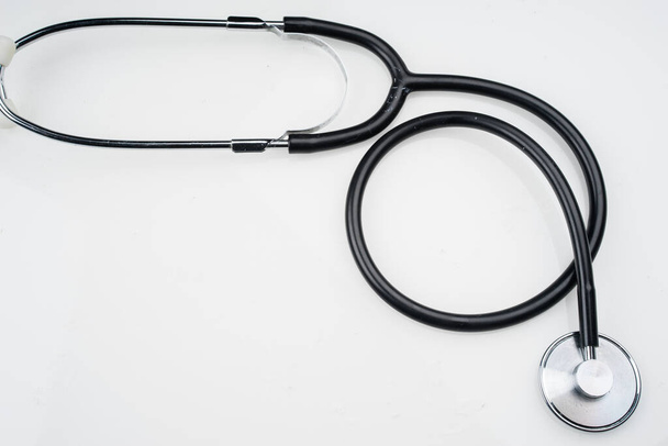 Medisch of gezondheidsconcept. Stethoscoop geïsoleerd op witte achtergrond. Vlakke lay of bovenaanzicht. - Foto, afbeelding