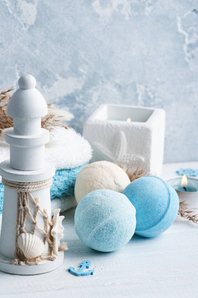 Bath bombs in blue white spa composition with dry flowers, lit aroma candles and towels. Aromatherapy arrangement, zen still life - Photo, Image