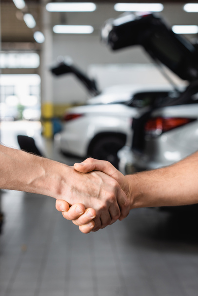 Selective focus of handshake gesture of men at service station - Photo, Image