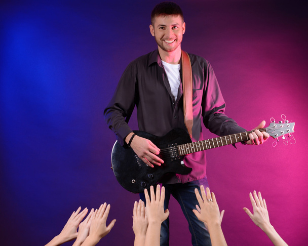 Guitarist singing on stage at a rock concert for his adoring fans - Foto, imagen