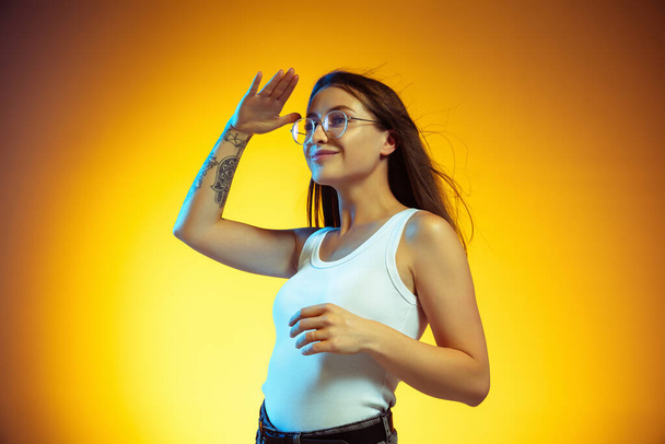 Portrait of young caucasian woman isolated on gradient yellow studio background - Φωτογραφία, εικόνα