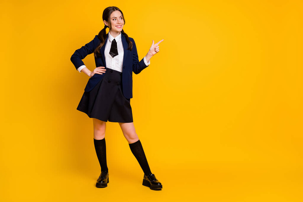 Full length body size view of her she nice attractive pretty glad cheerful cheery schoolgirl demonstrating copy space select advert ad isolated on bright vivid shine vibrant yellow color background - Foto, Bild
