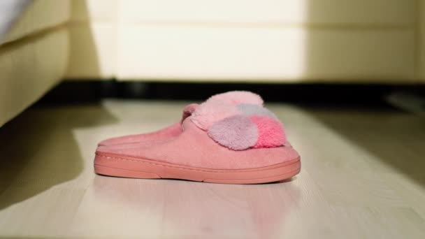 Zapatillas de mujer de color rosa de pie cerca de la cama, el hombre los viste por la mañana
 - Metraje, vídeo