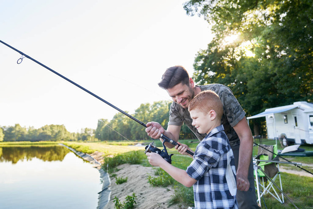 Petit fils enseigné par père comment faire de la pêche - Photo, image