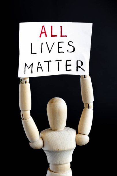 All Lives Matters protester. Wooden mannequin holding signs banner. All lives matter. Black background. Equality concept. - Photo, Image