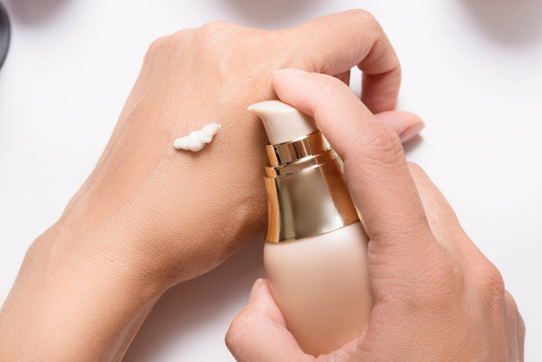 Applying cream to woman hands with dispenser - Foto, imagen