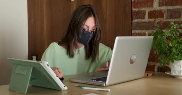 Femme en masque travaillant la nuit à l'aide d'un ordinateur portable - Séquence, vidéo