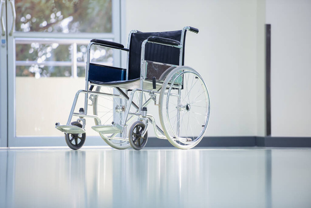 Rollstühle im Krankenhaus, Patient sitzt im Rollstuhl, Er hält seine Hände am Lenkrad, Selbsthilfekranke mit Mobilität. - Foto, Bild