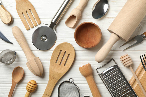 Different kitchen cutlery on white wooden background - Fotografie, Obrázek