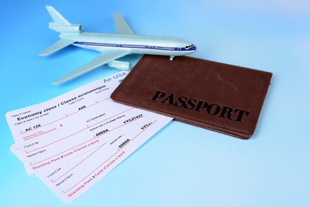 Açık mavi arka planda pasaportlu uçak biletleri. - Fotoğraf, Görsel