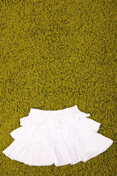 Beautiful skirt for little girl on green carpet - Zdjęcie, obraz