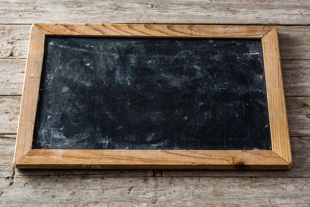Blackboard on wooden background with copy space - 写真・画像