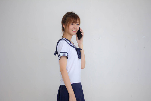 Retrato de tailandés adolescente hermosa chica en japonés estudiante uniforme llamando teléfono inteligente
 - Foto, Imagen