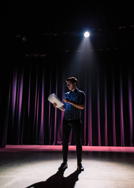 Medium shot of actors and actresses rehearsing a scene in a theater. Medium shot of an actor performing a monologue in a theater while holding his script - Fotó, kép