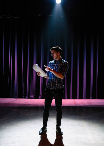 Medium shot of actors and actresses rehearsing a scene in a theater. Medium shot of an actor performing a monologue in a theater while holding his script - Foto, imagen