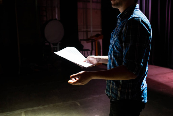 Medium shot of actors and actresses rehearsing a scene in a theater. Medium shot of an actor performing a monologue in a theater while holding his script - Fotoğraf, Görsel