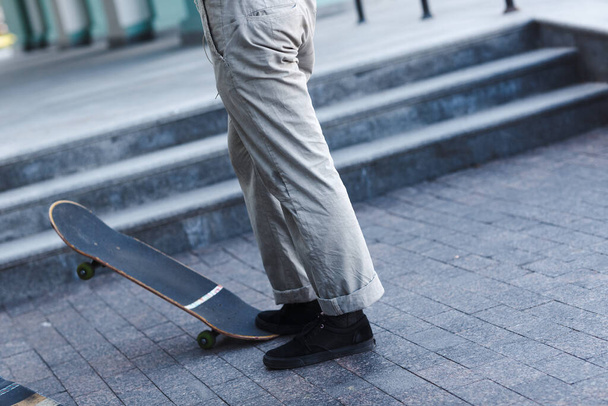 Jonge jongen skaten truc op skateboard in de stad - Foto, afbeelding