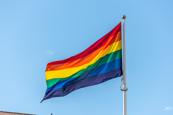 Bandera de arco iris HBTQ ondeando orgullosamente en la brisa
 - Foto, imagen