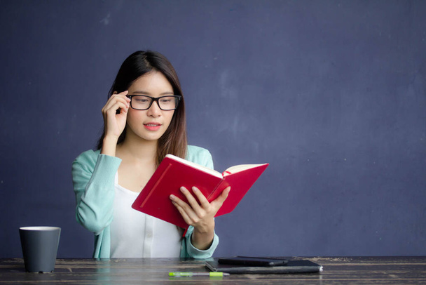 tailandês china adulto escritório menina óculos branco camisa leitura vermelho livro
 - Foto, Imagem