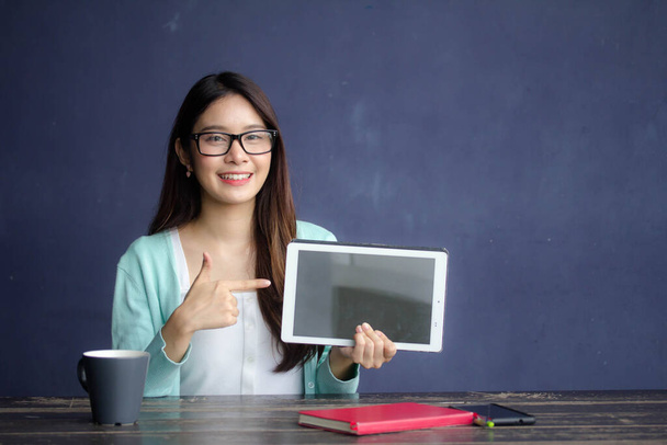 Тайский фарфор взрослого офиса девушка очки белая рубашка показать свой планшет
. - Фото, изображение