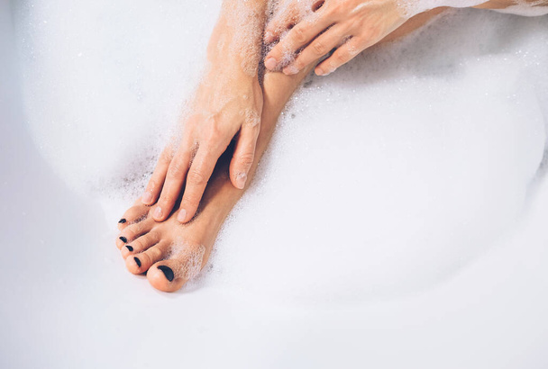 Well grooming woman's legs and hands in bath foam close up image - Fotoğraf, Görsel