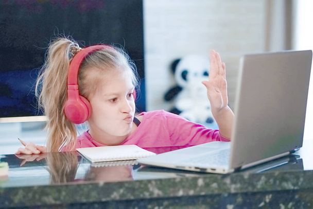 幸せな若い女の子の選択された焦点は、ヘッドフォンの時計のウェビナーを着用オンラインコースの通信を聞く会議ビデオ通話eは自宅でノートパソコンを見て先生のレッスンと語学学習を学びます. - 写真・画像