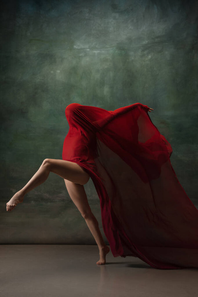Young graceful tender ballerina on dark green studio background - Foto, imagen