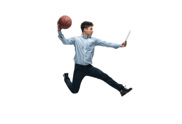 Man in office clothes playing basketball on white background. Unusual look for businessman in motion, action. Sport, healthy lifestyle. - Foto, Imagem