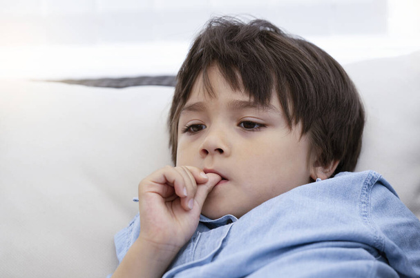 Portrait of little boy biting his finger nails while watching TV,Head shot kid with deep in thought, Childhood and family concept, Emotional Child portrait. - Photo, image