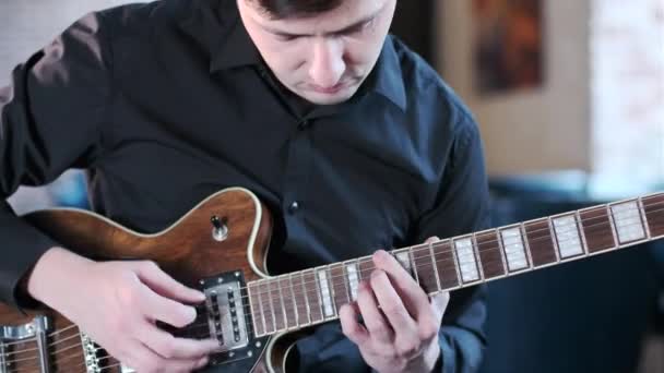 young guitarist in a black shirt performs a blues musical improvisation in a bar. Retro studio, brick interior. Jazz, Blues, Funk. Closeup - Záběry, video