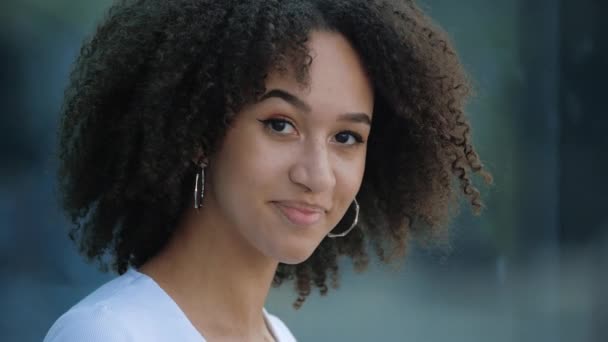 Attractive young afro girl smiles at camera showing hand OK sign. Student shows everything fine success gesture body language. African american millennial curly hair woman smiling, evaluation concept - Footage, Video