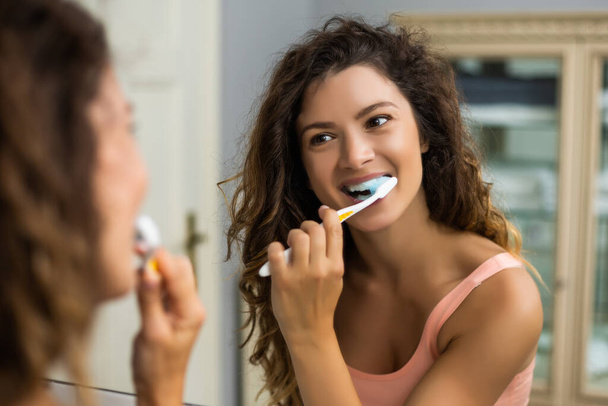 Beautiful woman brushing teeth in the bathroom. - Zdjęcie, obraz