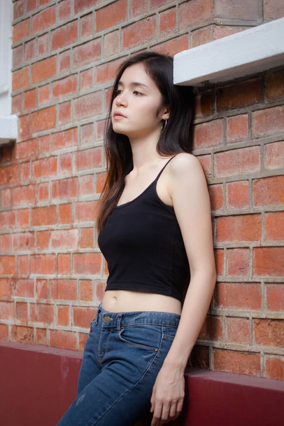 Portrait of thai china adult beautiful girl black shirt blue jeans relax and smile - Zdjęcie, obraz