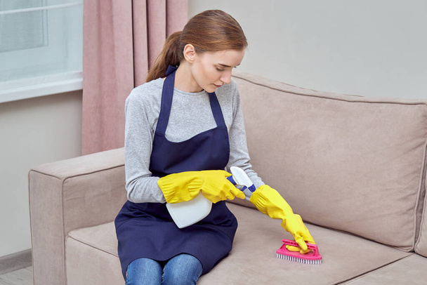 Cleaning of furniture with household chemicals. Girl with gloves. - Fotó, kép