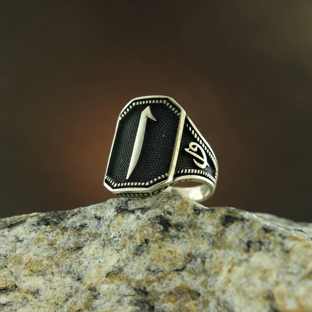 Srebrny pierścień męski wzorowany na czarnym tle - Zdjęcie, obraz