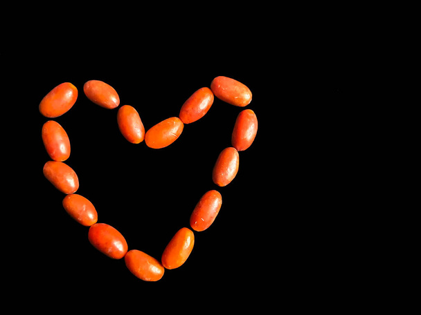 Love shape made of small south asian Dates with a black background. Love - Photo, Image