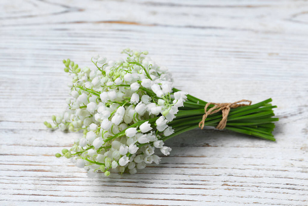 Beautiful lily of the valley flowers on white wooden table - Photo, image