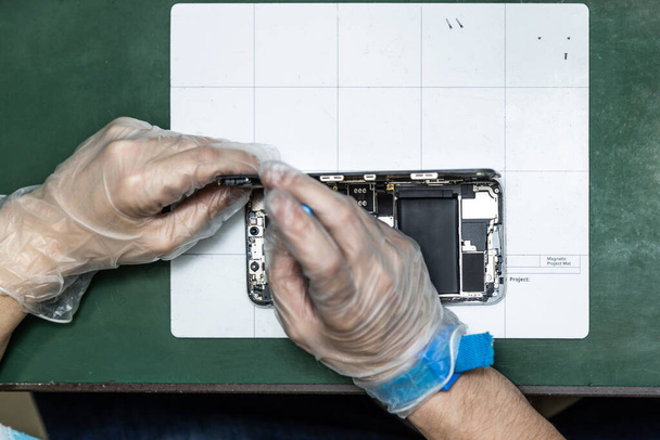 técnico irreconocible reparar el teléfono inteligente en su taller de reparación
 - Foto, Imagen