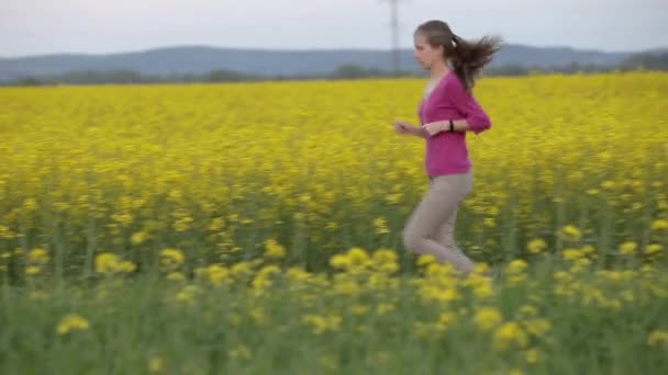 Młoda kobieta biegająca po kwitnących polach. - Materiał filmowy, wideo