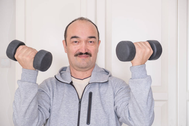 Asijský muž v activewear dělá fitness doma se sportovním vybavením. - Fotografie, Obrázek