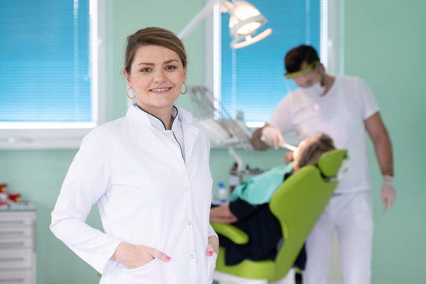 boldog fiatal női fogorvos orvosi háttér, fogászat és egészségügyi koncepció - Fotó, kép