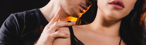 panoramic crop of man touching sexy woman isolated on black  - Photo, Image