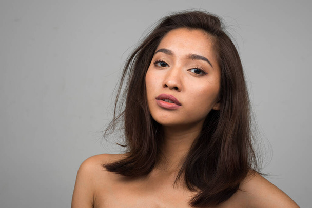 Studio shot of young beautiful Asian woman   - Foto, imagen