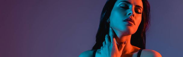 cosecha horizontal de mujer joven sexy tocando cuello aislado en púrpura
  - Foto, imagen