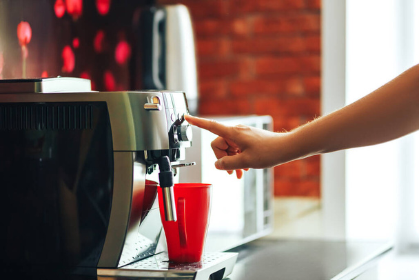 Close-up máquina de café fazendo café fresco pela manhã, máquina de café e caneca vermelha
. - Foto, Imagem